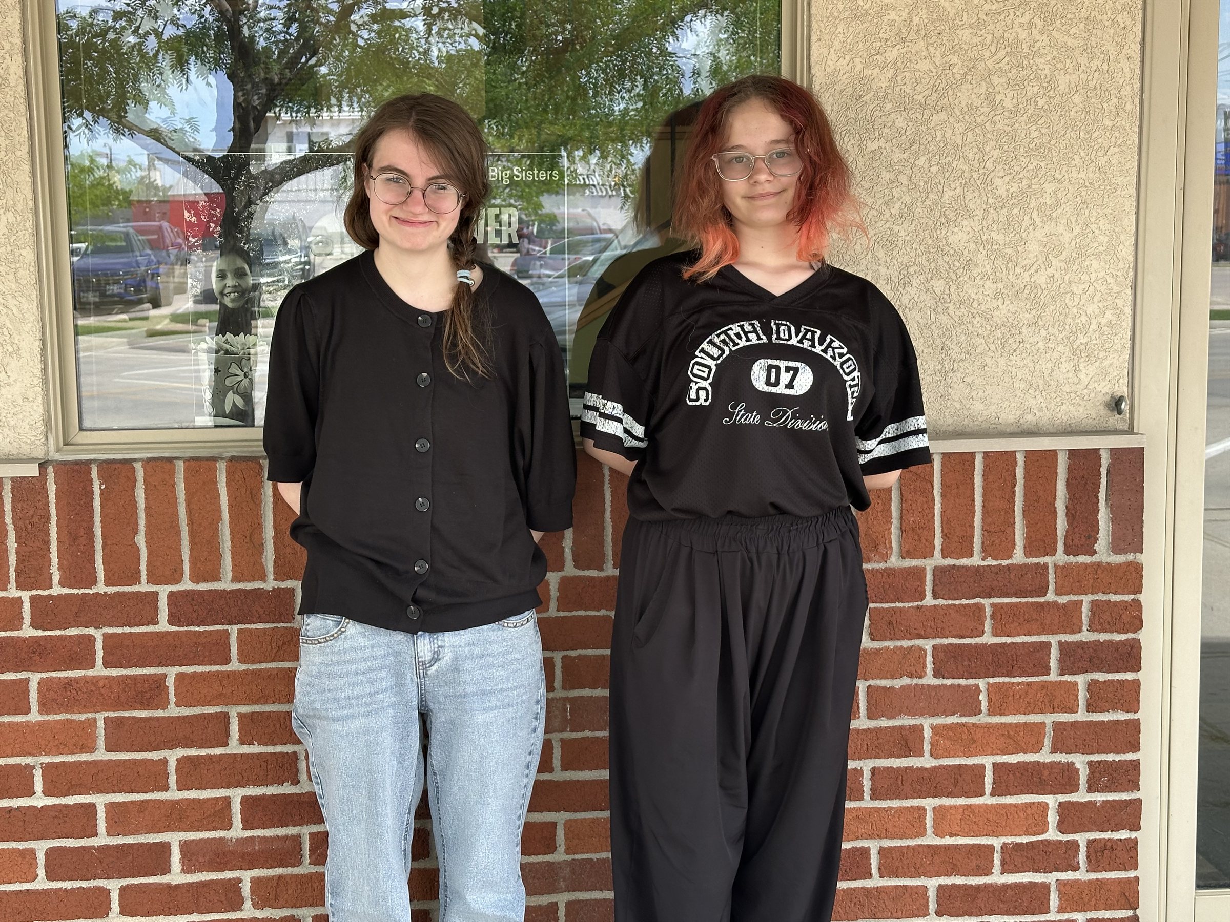 A Big and Little standing side by side outside the Big Brothers Big Sisters of the Black Hills office
